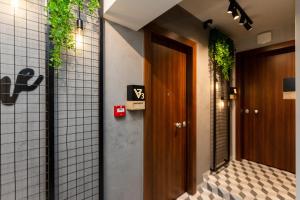 塞萨洛尼基Valaoritou 3 Luxury Rooms的走廊上挂有门,墙上挂有植物