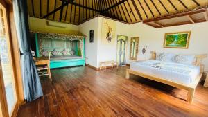 姆杜克Sri Lestari Banyuatis的一间卧室设有一张大床,铺有木地板