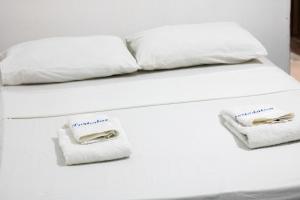 贝伦Hotel Porto da Lua Belém的一张带白色床单和毛巾的床