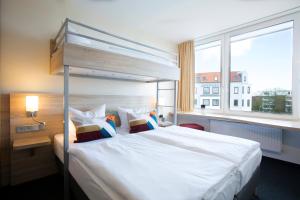 不来梅港弗洛登齐尔大西洋酒店的卧室设有一张白色大床和一扇窗户。