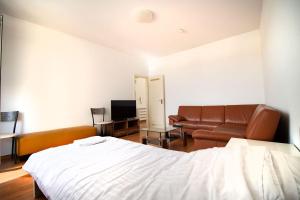 贝尔吉施格拉德巴赫Apartment Centrum Bergisch Gladbach的一间卧室配有一张床、一张沙发和一台电视