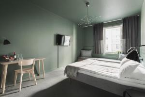卑尔根Heimen Hotel的一间卧室配有一张床、一张书桌和一个窗户。