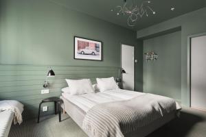 卑尔根Heimen Hotel的一间卧室配有一张带绿色墙壁和吊灯的床。