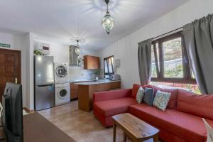 贝加德圣马特奥Apartamento Gran Canaria La Mariposa的一间带红色沙发的客厅和一间厨房