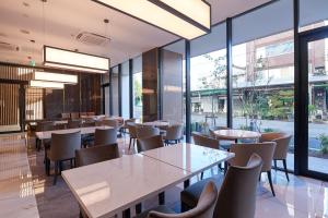 东京Tosei Hotel Cocone Tsukiji Ginza Premier的餐厅设有桌椅和大窗户。