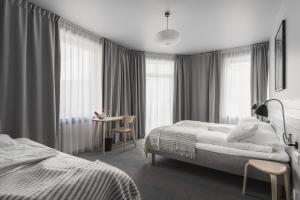 卑尔根Heimen Hotel的一间卧室设有两张床、一张桌子和窗户。