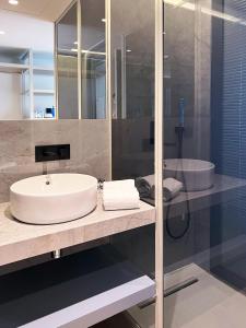 波尔图Oca Bom Sucesso Hotel的浴室配有白色水槽和浴缸。