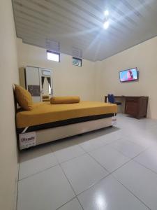 BonorejoSolo Nadamax City Guest House Syariah的一间卧室配有一张床,墙上配有电视