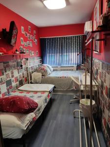 马德里Villaverde Rooms, privada baño compartido的红色墙壁客房的两张床