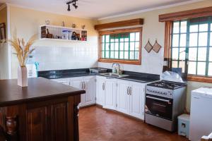 安博塞利Wild Amboseli Ndovu Cottage.的厨房配有白色橱柜和炉灶烤箱。