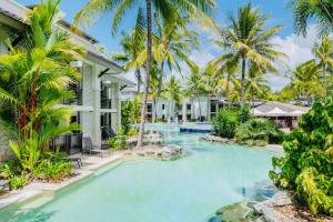 道格拉斯港Paradise Escape - Poolside Ground Floor - Sea Temple Resort and Spa的棕榈树屋前的游泳池