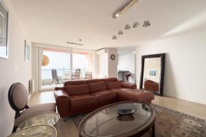滨海比拉萨尔Impresionante Apartamento delante del Mar的客厅配有棕色皮沙发和桌子