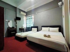 Kuala KeraiRz Gold Hotel Official Account的一间卧室配有两张床和镜子
