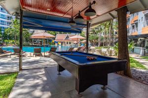 芭堤雅市中心Heeton Concept Hotel Pattaya by Compass Hospitality的游泳池旁天井上的台球桌