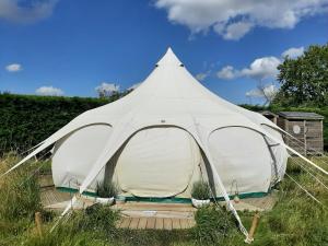 CawstonWild Retreat的坐在田野上的白色大帐篷