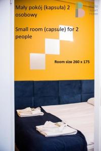 华沙Bello ApartHostel的一间设有床铺的房间,上面有两条毛巾
