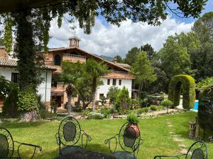 阿罗约弗里奥德拉谢拉圣玛丽亚修道院乡村酒店的房屋前方设有庭院和椅子