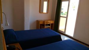 坎帕斯蒂利亚巴里酒店的一间卧室设有蓝色的床和窗户。