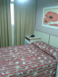 里约热内卢委内瑞拉酒店的酒店客房,配有一张带红白毯子的床