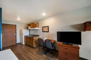沃思堡WoodSpring Suites Fort Worth Fossil Creek的一间小房间,设有厨房和一台电视机