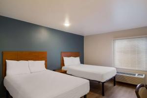 杰克逊维尔WoodSpring Suites Jacksonville I-295 East的酒店客房设有两张床和窗户。