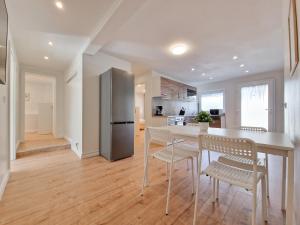 梅尔布施RAJ Living - 3 Room Apartments - 20 Min to Messe DUS & Old Town DUS的厨房配有桌椅和冰箱。