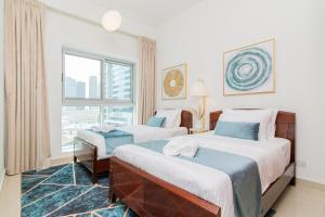 迪拜Cozy 2BR Delux Apartment in Dubai Marina的酒店客房设有两张床和窗户。