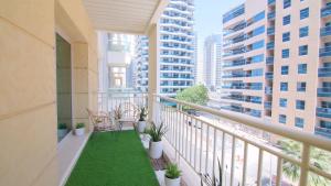 迪拜Cozy 2BR Delux Apartment in Dubai Marina的阳台设有椅子和植物,拥有建筑