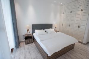 博瓦隆Waterlily Guesthouse的一间卧室配有一张带白色床单的大床
