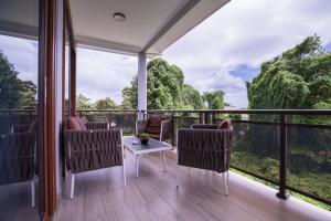 博瓦隆Waterlily Guesthouse的客房设有带桌椅的阳台。