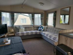 布里恩2 Brightholme 6 berth with Decking & enclosed gard的带沙发和电视的客厅