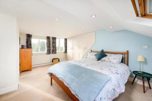 伦敦Modern 3 bedroom house with garden view的一间卧室配有一张带蓝色棉被的大床