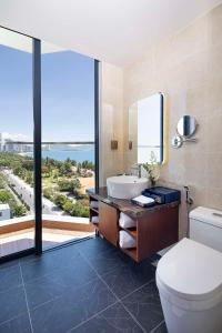 芽庄Best Western Premier Marvella Nha Trang的一间带水槽和卫生间的浴室以及窗户。
