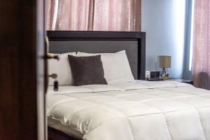 特马Afranasa Inn的一间卧室配有一张白色大床和黑色床头板