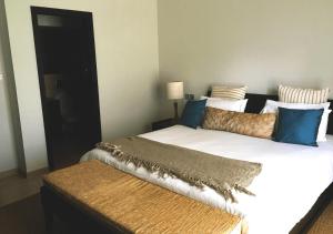 Centre de FlacqPrivate Beach 5-star Villa, Golf & Luxe的一间卧室配有两张带蓝色和金色枕头的床