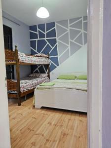维利波吉Titi's home Velipoje的一间卧室设有两张双层床,铺有木地板。