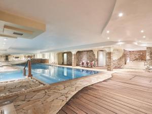 布伦托尼科Hotel Dolomiti的大型游泳池位于酒店客房内,