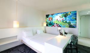 科隆art'otel cologne, Powered by Radisson Hotels的一间设有白色床和壁画的房间