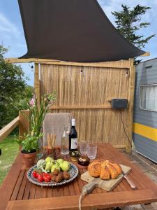 NitonPuckaster Cove Garden Yurt的一张带食物和一瓶葡萄酒的桌子