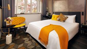 阿姆斯特丹公园广场酒店&度假村的一间卧室配有一张大床和一张黄色椅子