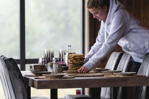 AurdalSki inn-ski ut hytte i Aurdal - helt ny的站在桌子上一边吃着食物的女人