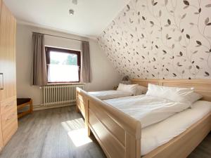 翁德洛Ferienwohnung Neumair的一间卧室设有一张床,墙上有树叶