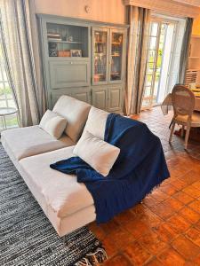 勒帕莱Gite Gilles的客厅里一张白色的沙发,上面有蓝色的毯子