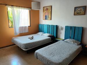 Valle de GuerraLagarto Hostel Tenerife的一间设有两张床的房间和床上的一只动物