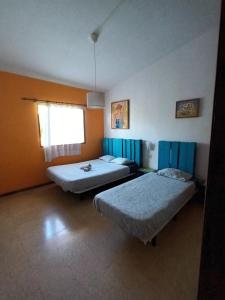 Valle de GuerraLagarto Hostel Tenerife的客房设有两张床和窗户。