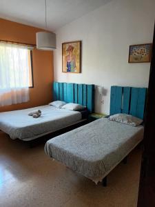 Valle de GuerraLagarto Hostel Tenerife的蓝色调的客房内的两张床