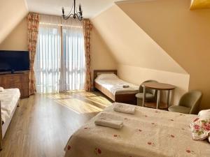 Białka Tatrzanska波德丽帕2号旅馆的一间卧室配有两张床、一张桌子和一台电视。