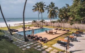 迪亚尼海滩LalaGalu - Beachfront EcoCabins的棕榈树海滩旁的游泳池