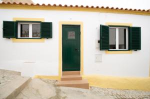马林堡Comfortable getaway in Medieval Castro Marim的白色的建筑,设有绿色的窗户和门