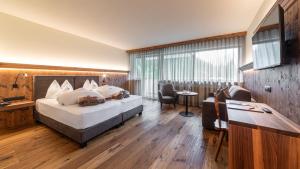 多比亚科桑特罗曼蒂克酒店的酒店客房设有一张大床和一张书桌。